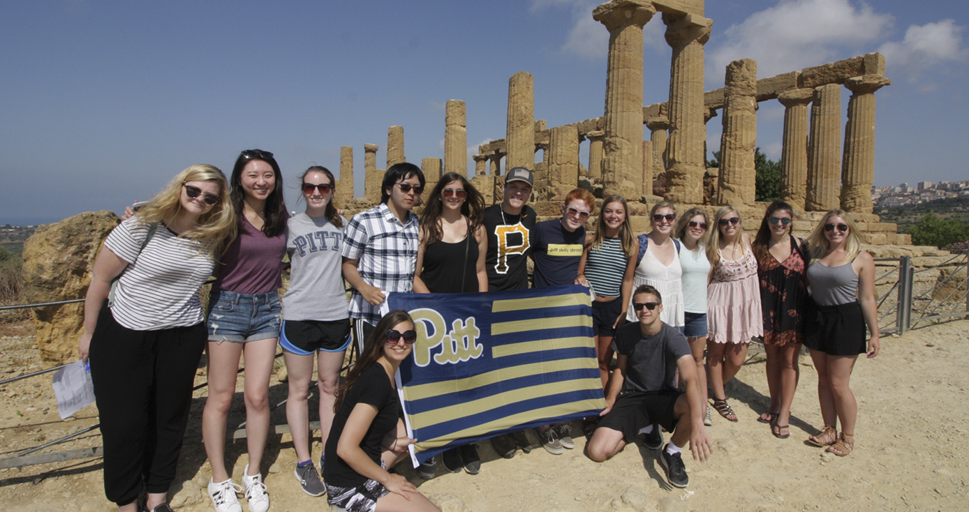 Group of students in Sicily holding a Pitt flag