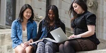Three students studying together on outdoor steps